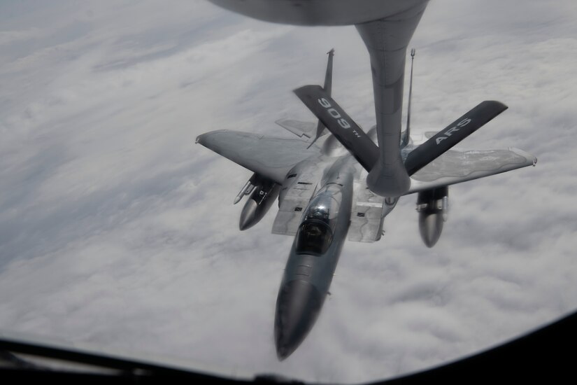 A photo of a fighter aircraft refueling while flying