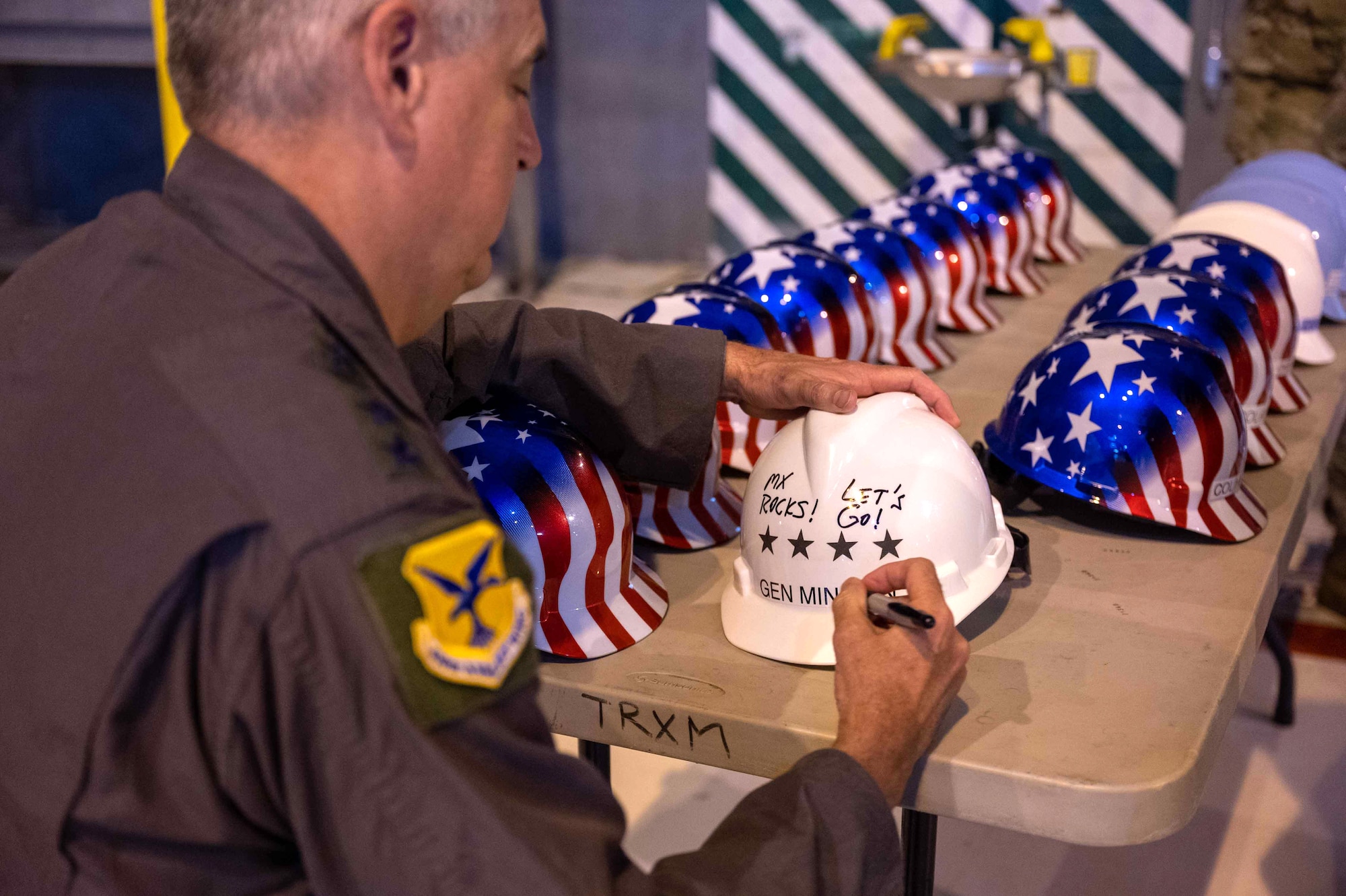 Gen. Mike Minihan, Air Mobility Command commander, signs a safety helmet at the C-5 Isochronal Dock at Dover Air Force Base, Delaware, May 5, 2022. During his visit, Minihan was briefed on Iso-dock operations and a new innovative workflow to expedite aircraft maintenance. (U.S. Air Force photo by Senior Airman Faith Schaefer)