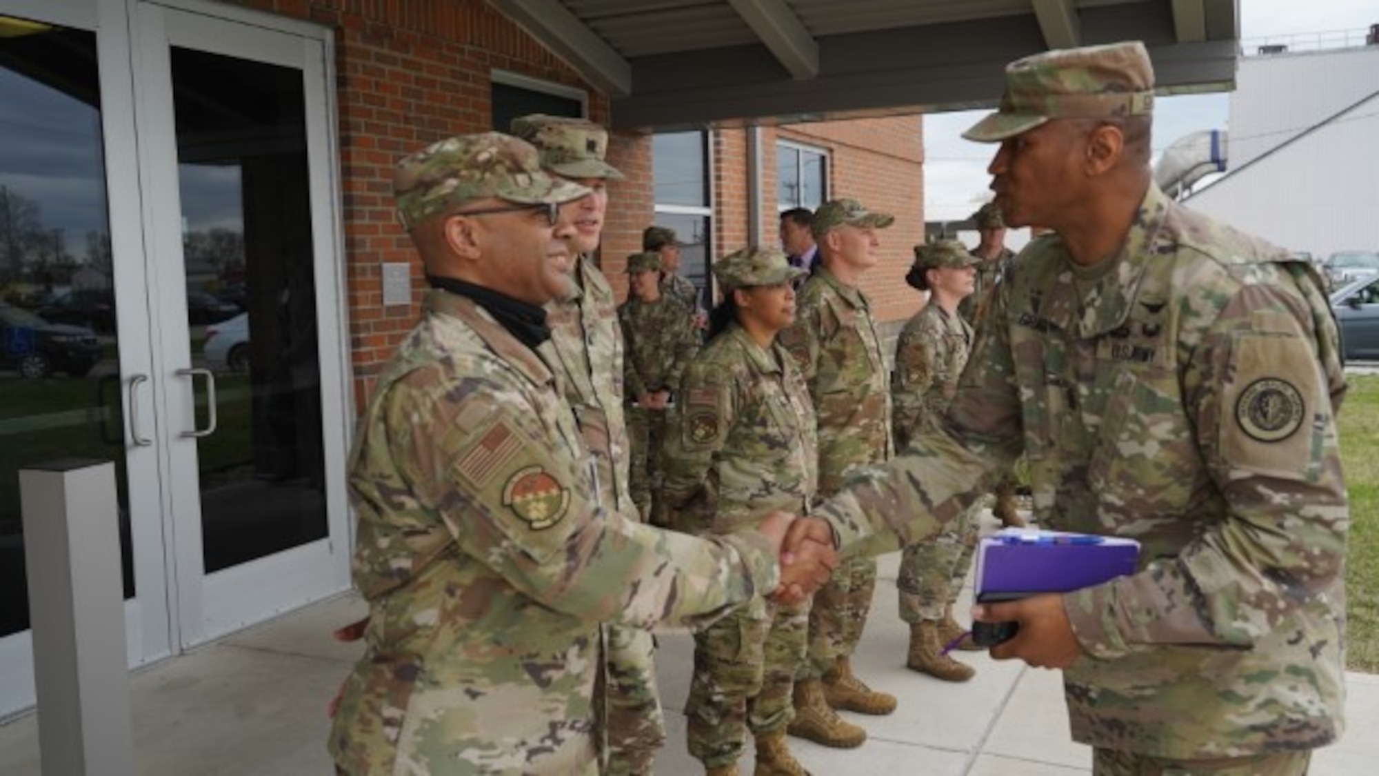 Air Force Lt. Col. Keye Latimer, 88th Diagnostic and Therapeutic Squadron commander, welcomes Army Command Sgt. Maj. Michael Gragg, Defense Health Agency senior enlisted leader, outside Kittyhawk Pharmacy at Wright-Patterson Air Force base, Ohio on April 12, 2022. Gragg visited the medical center to see its missions and capabilities firsthand. (U.S. Air Force photo by Kenneth Stiles)