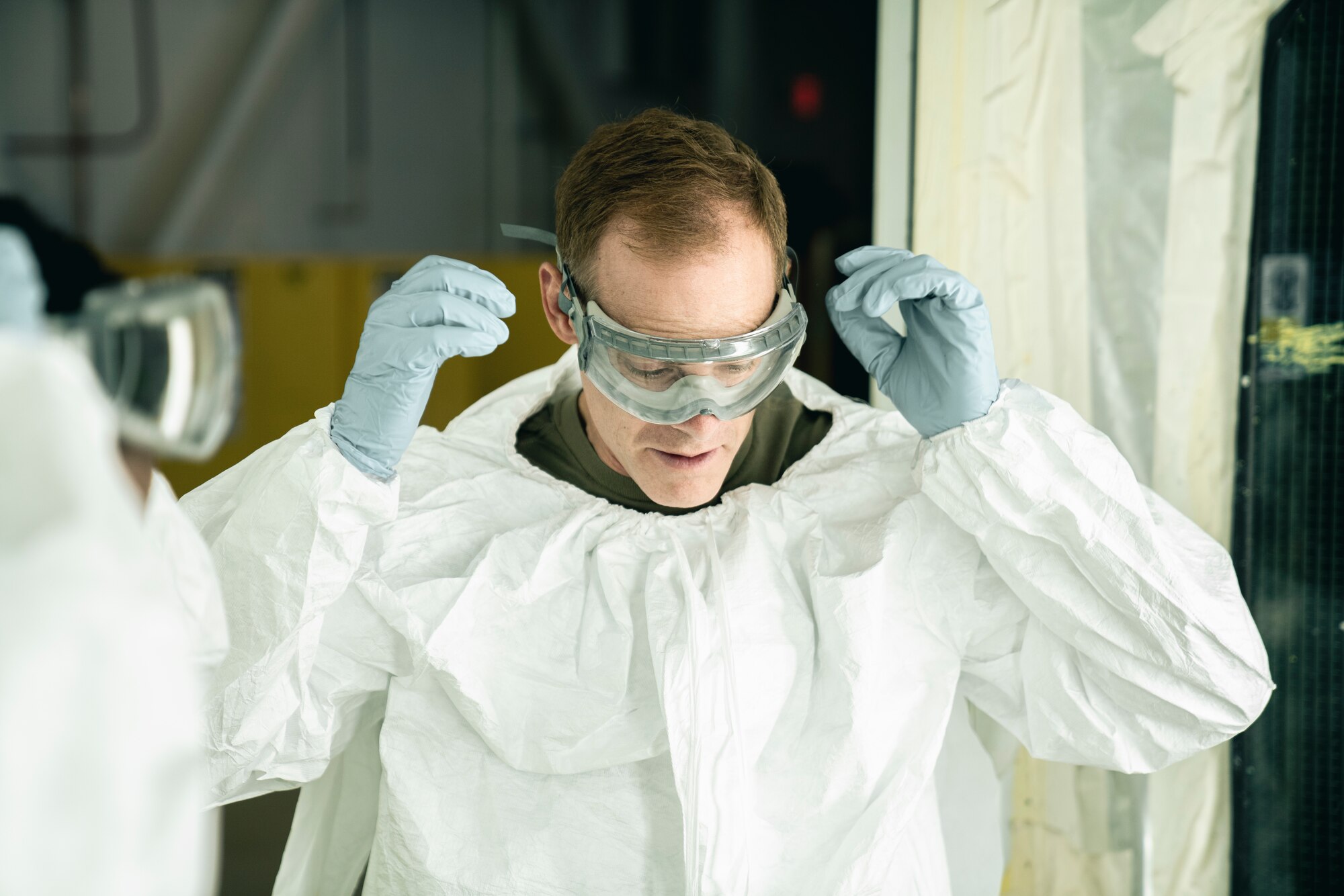 U.S. Air Force Col. Benjamin Jonsson, 6th Air Refueling Wing commander, puts on personal protective equipment prior to painting aircraft parts in the corrosion control facility at MacDill Air Force Base, Florida, April 28, 2022.