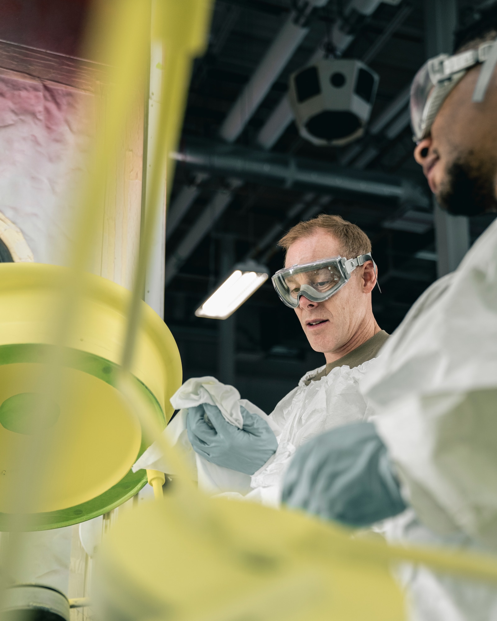 U.S. Air Force Col. Benjamin Jonsson, left, 6th Air Refueling Wing commander, and U.S. Air Force Senior Airman Bryce Johnson, 6th Maintenance Squadron aircraft structural maintenance apprentice, prepare to paint an aircraft part in the corrosion control facility at MacDill Air Force Base, Florida, April 28, 2022.
