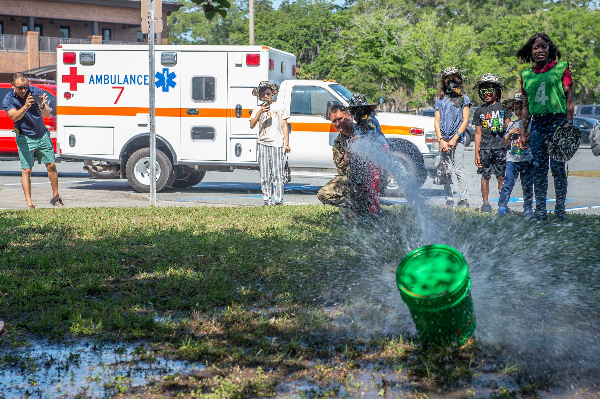 kid shooting water on a green bucket