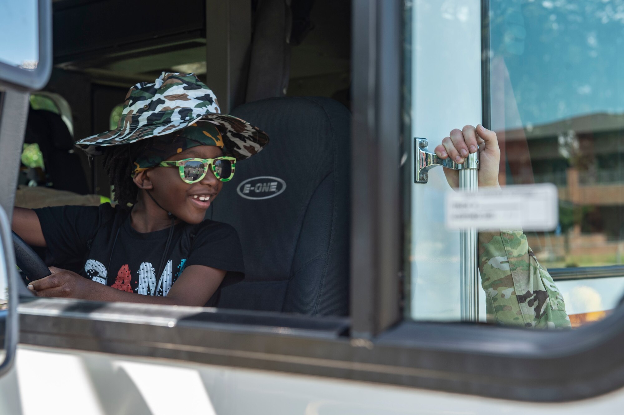 kid wearing shades in a fire truck