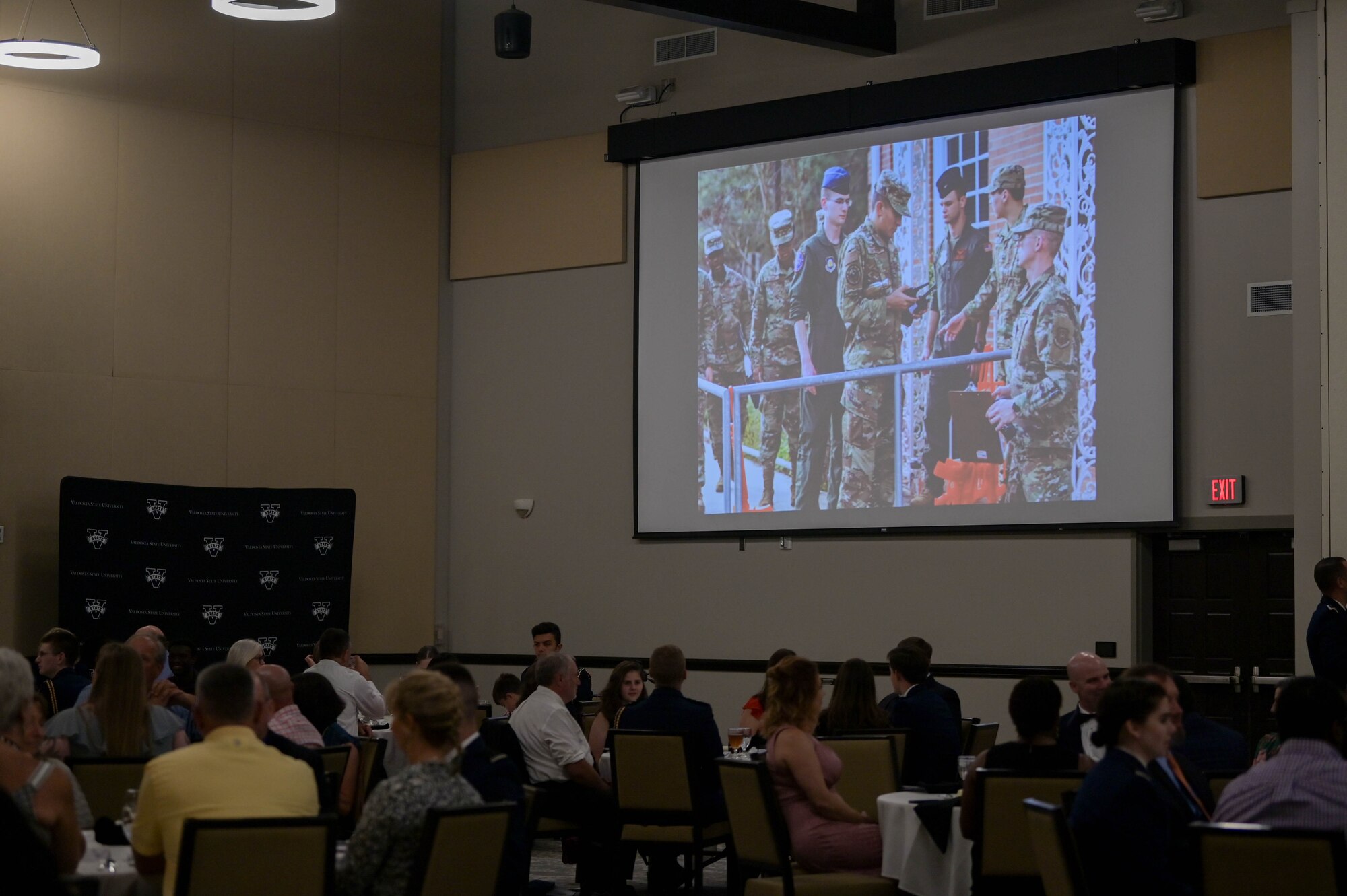 Attendees watch cadet training highlights at the Air Force ROTC Detachment 172 awards ceremony at Valdosta State University, Georgia, April 27, 2022. The ceremony celebrated graduating cadets and also passed the responsibilities of cadet leadership to rising seniors. (U.S. Air Force photo by Senior Airman Rebeckah Medeiros)