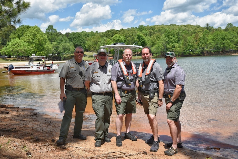 The U.S. Army Corps of Engineers, Lake Sidney Lanier park ranger team pose for a photo prior to boarding their patrol boats, May 3, 2022, in support of helocast training at Lake Lanier, Georgia. (From left to right) Ernest Noe, Chief Ranger, Tyler Sessions, Mark Millwood, Mike Axton, Steve Cahn, park rangers, ensured visitor and jumper safety. (U.S. Army photo by Christopher Carranza)