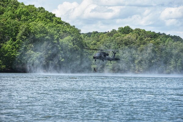 A Soldier from the 5th Ranger Training Battalion jumps from a UH-60 Black Hawk helicopter into Lake Lanier, Georgia, May 3, 2022. Helocasting is an insertion technique developed by Airborne troops whereby Soldiers step off the aircraft's ramp at a low altitude and low speed directly into the water below. (U.S. Army photo by Christopher Carranza)