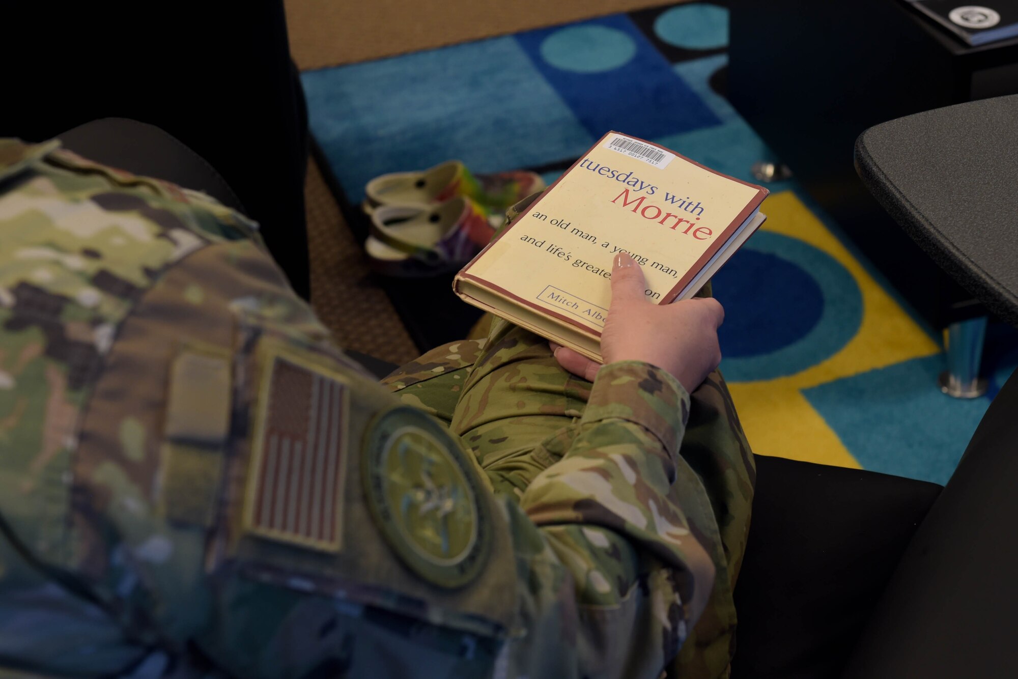 A photo of a book on an Airman's lap.