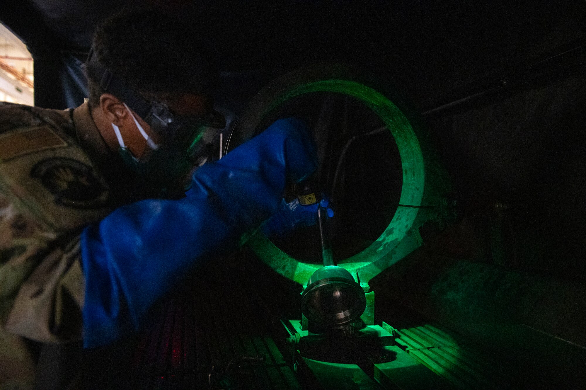 Fluorescent iron particles in the mixture become magnetized inside cracks or defects making them visible and glow under a black light. (U.S. Air Force photo by Senior Airman Kylie Barrow)
