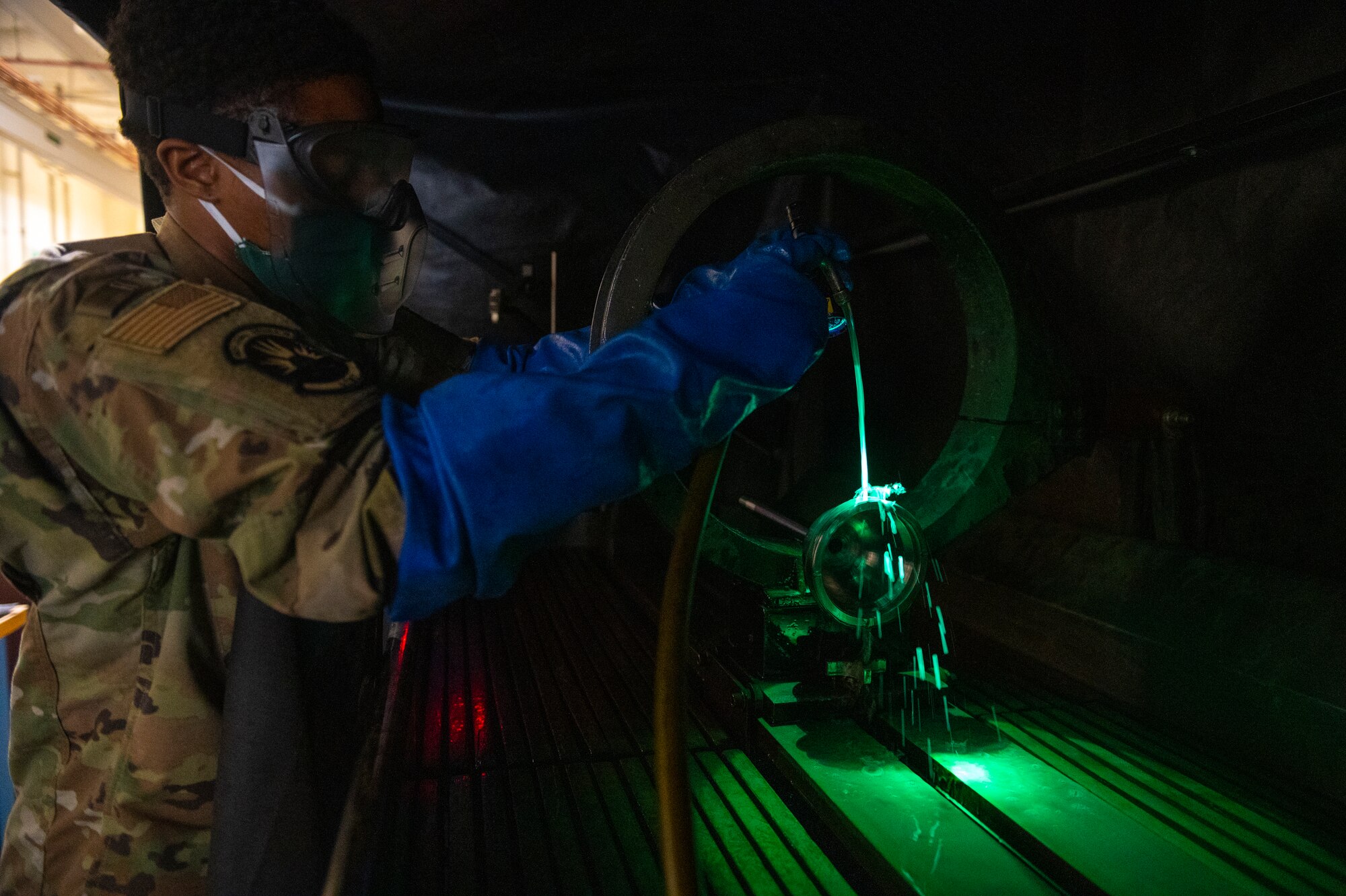 Madison used the magnetic particle mixture, made up of oil and fluorescent iron particles, to help identify aircraft equipment defects under a black light. (U.S. Air Force photo by Senior Airman Kylie Barrow)