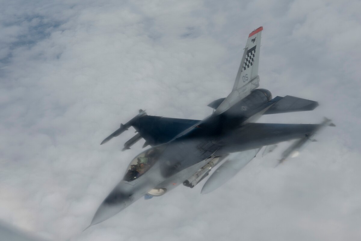 A photo of a fighter aircraft refueling while flying