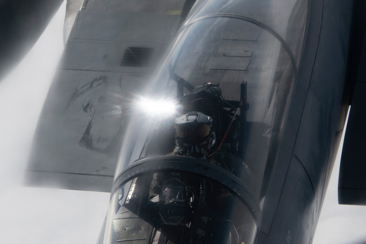 A photo of a fighter aircraft refueling while flying