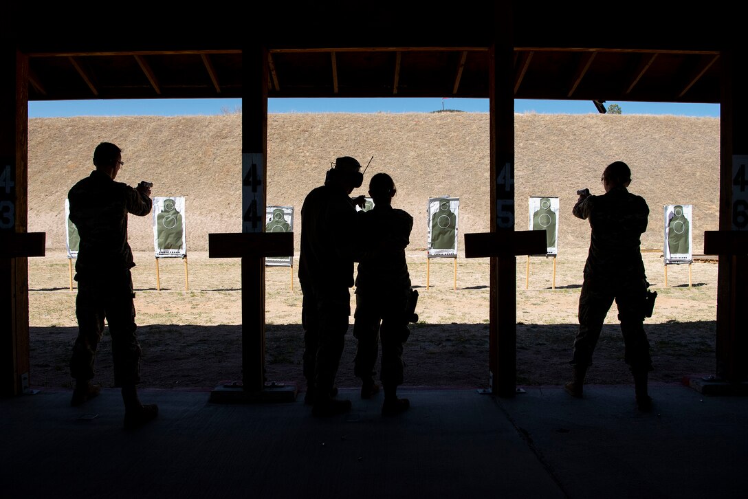 A group of cadets aim at targets at a range.