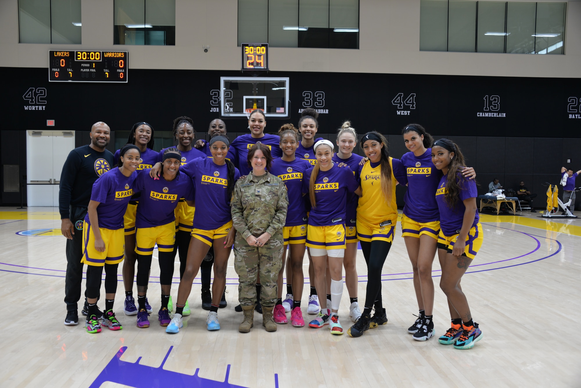 Col. Jennifer M. Krolikowski, center, joins L.A. Sparks team members and head coach Derek Fisher following her recent motivational talk about leadership and personal and professional challenges.