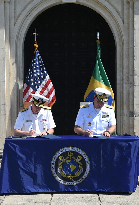 Rear Adm. Jim Aiken and Brazilian navy Adm. Gustavo Calero Garriga sign the minutes  during the closing ceremony of the 27th annual Maritime Staff Talks.