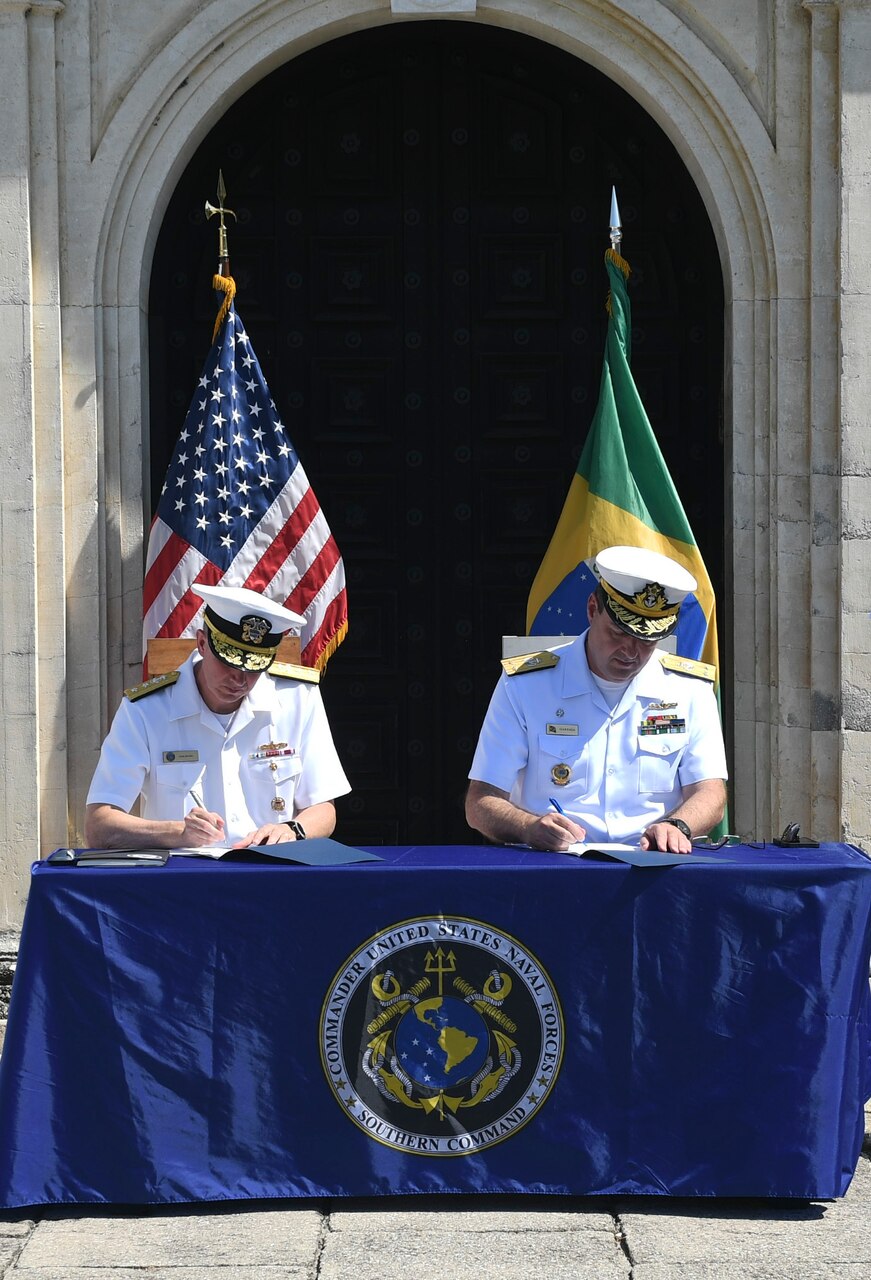 Rear Adm. Jim Aiken and Brazilian navy Adm. Gustavo Calero Garriga sign the minutes  during the closing ceremony of the 27th annual Maritime Staff Talks.