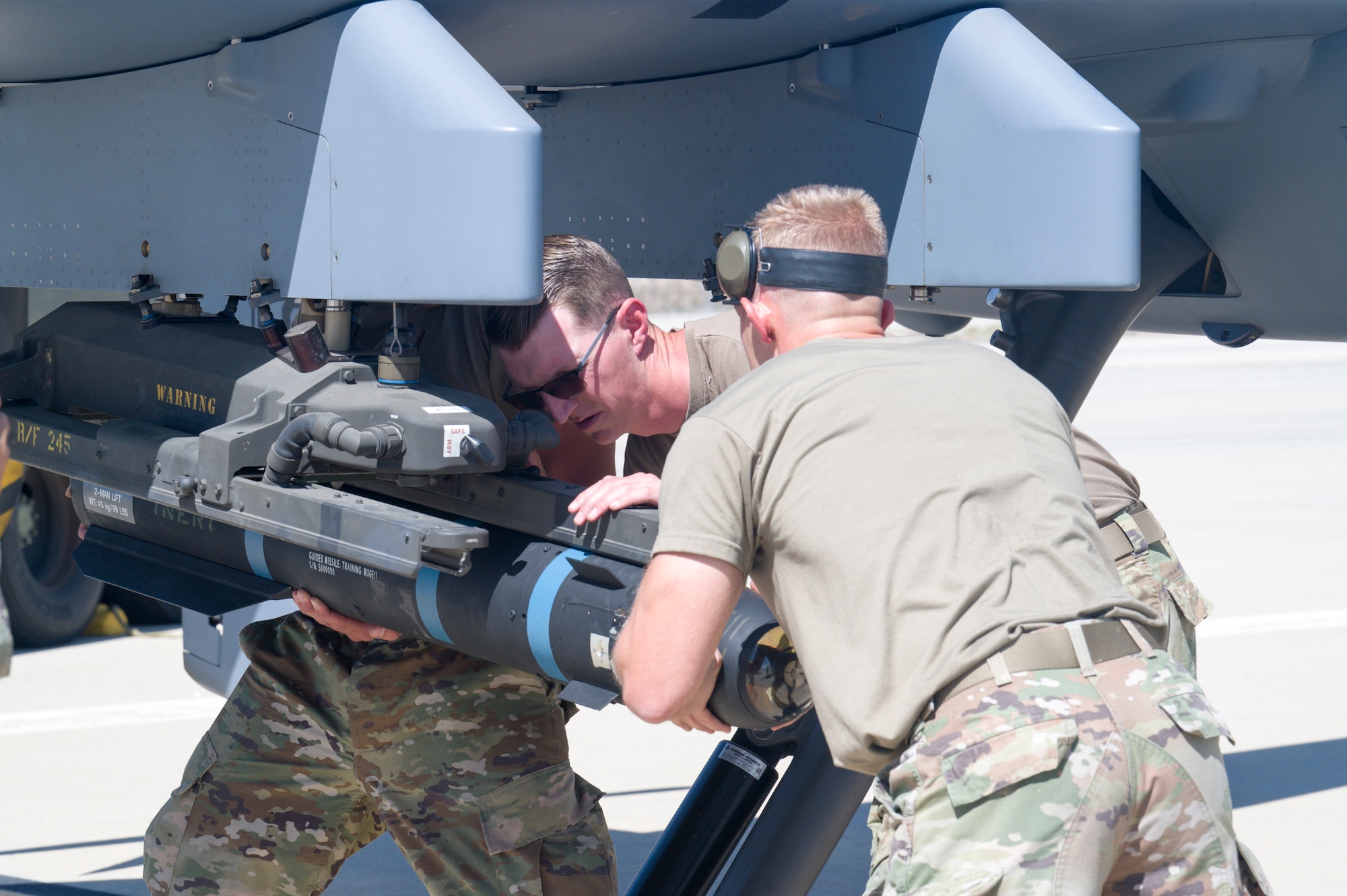 Airmen from the 163rd Attack Wing, out of March Air Reserve Base, load inert training weapons to an MQ-9 Reaper at Edwards Air Force Base, California, May 4. The aircraft conducted an Agile Combat Employment (ACE) to a Forward Operating Site (FOS), flying from March Air Reserve Base to Edwards Air Force Base. (Air Force photo by Giancarlo Casem)