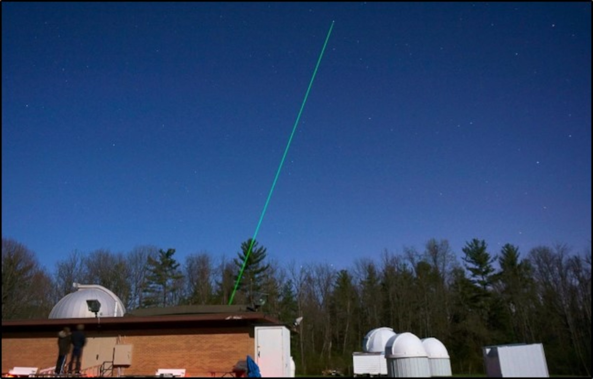 JBO laser with safety spotters outside observatory