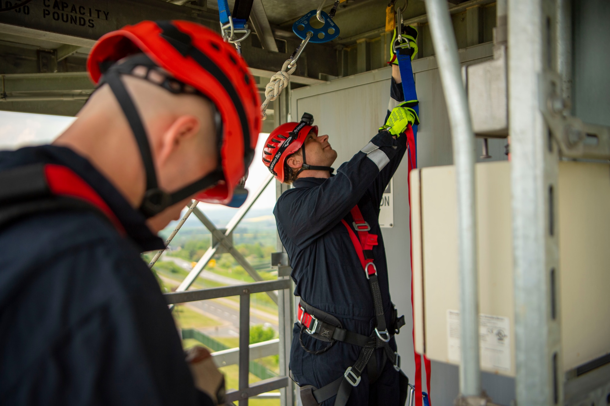 Marcel Buetzer, 52nd Civil Engineer Squadron firefighter, prepares rappel equipment for a Fall Rescue demonstration at the  radar tower, May 4, 2022, on Spangdahlem Air Base, Germany. The 52nd Fighter Wing Safety office observed the National Safety Stand-Down week to prevent falls in construction to stress the importance of educating and understanding the fall protection program in all affected work sections. (U.S. Air Force photo by Airman 1st Class Jessica Sanchez-Chen)