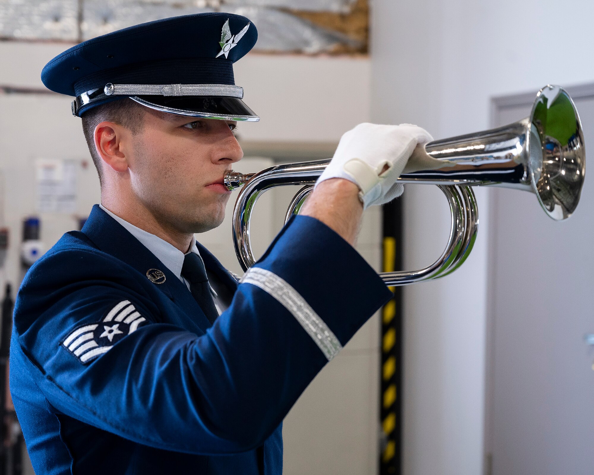 Staff Sgt. George Merusi, a new member of the Wright-Patterson Air Force Base Honor Guard, demonstrates the playing of “Taps” as part of a military funeral during the honor guard’s graduation ceremony, April 25, 2022. The bugle holds a hidden speaker that plays the music so that Airmen on six-month temporary duty do not need to learn how to play a musical instrument. (U.S. Air Force photo by R.J. Oriez)