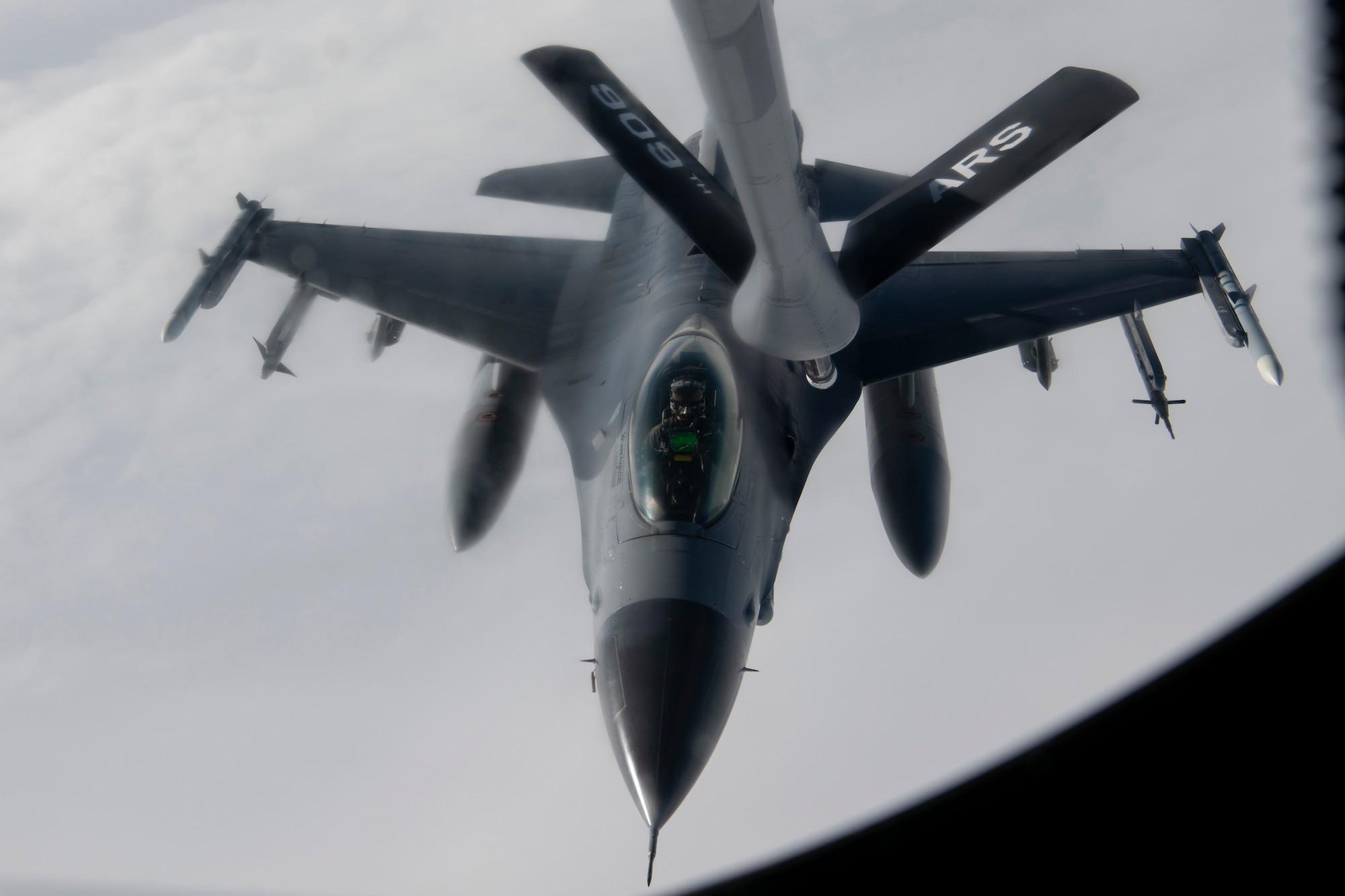 A photo of a fighter aircraft refueling while flying