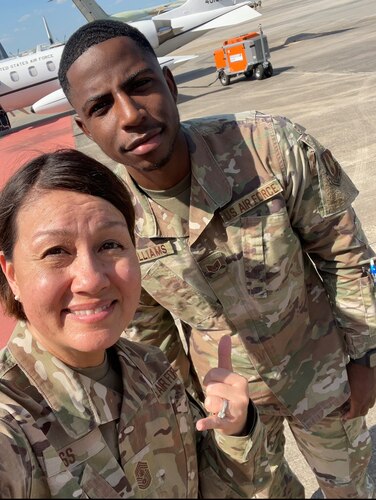 Photo shows two people posing for a selfie on the flight line.