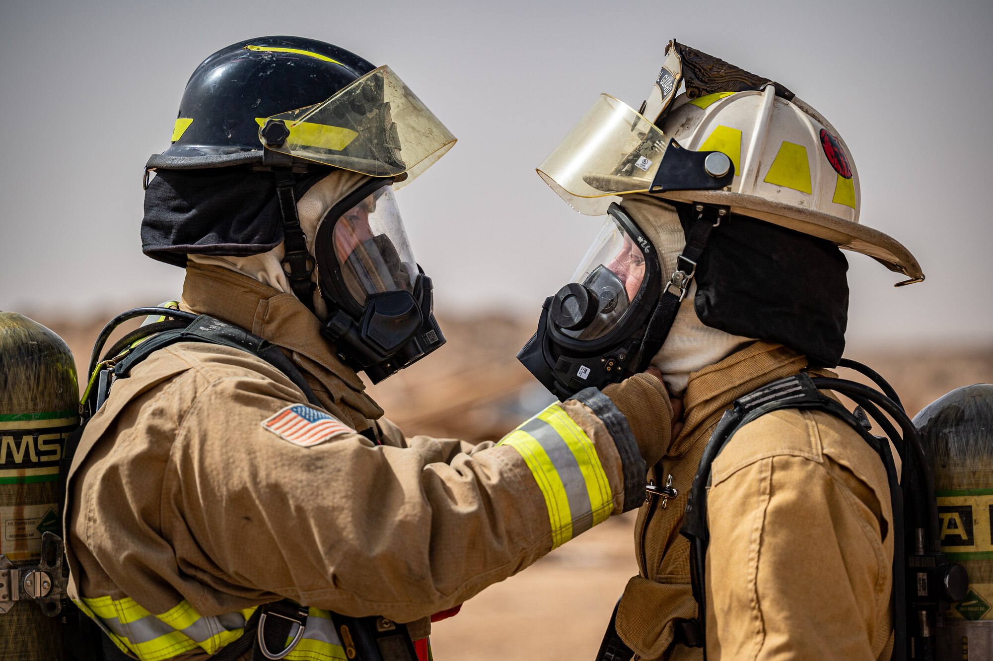 A 332d Expeditionary Civil Engineer Squadron firefighter inspects Lt. Col. Lee Turcottte, 332d ECES commander, as part of the buddy check process during live-fire flashover training at an undisclosed location in Southwest Asia, April 30, 2022. (U.S. Air Force photo by Master Sgt. Christopher Parr)