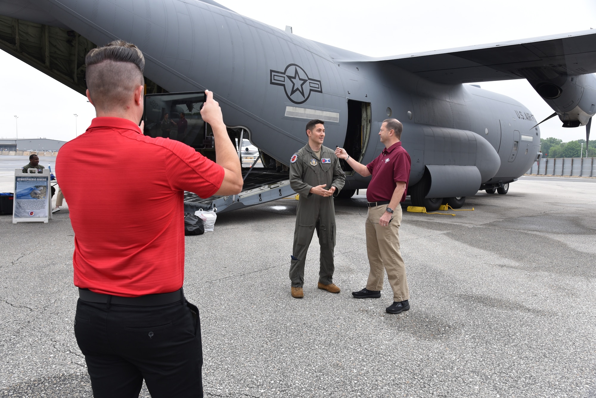NOAA members video and interview Air Force Reserve aerial reconnaissance weather officer next to a WC-130J Super Hercules.