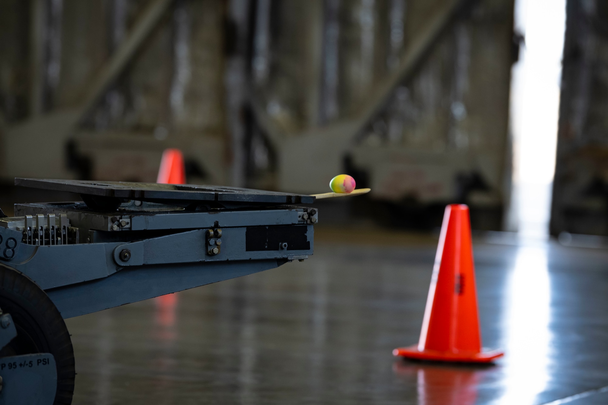 An egg sits on the edge of a lift truck.