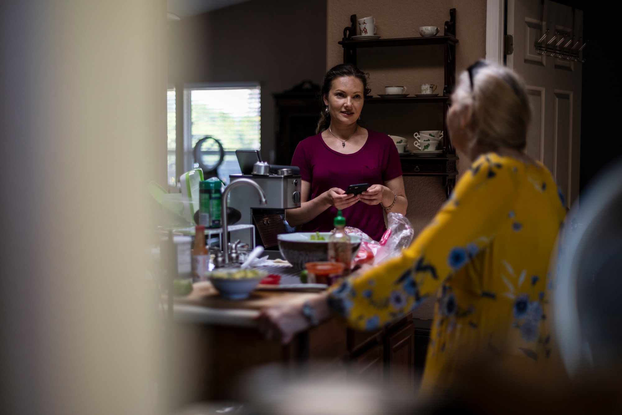 Two women standing in a kitchen.