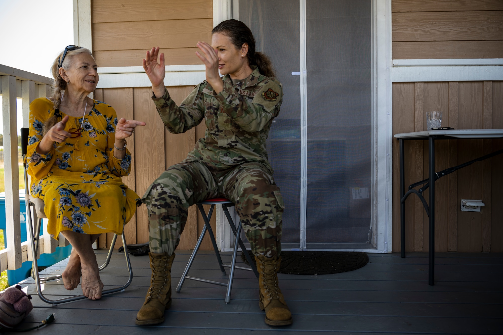 Two women sit on their front porch.