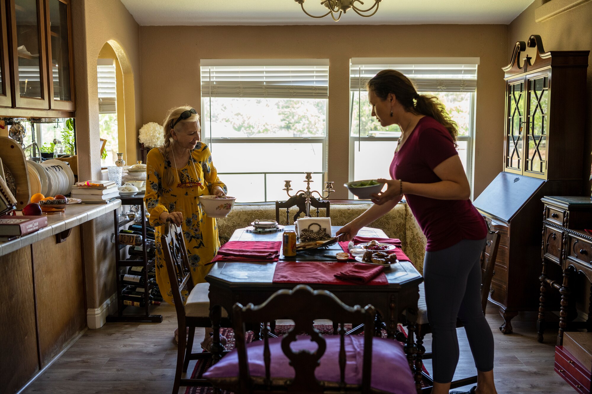 Two women standing around a table.