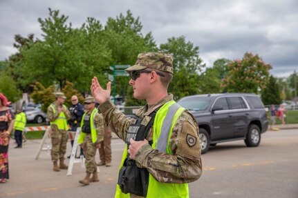 Pfc. Steven Hensen of the 223rd Military Police Company directs traffic and pedestrians at the 148th Kentucky Derby at Churchill Downs, Louisville, KY, May 7, 2022.