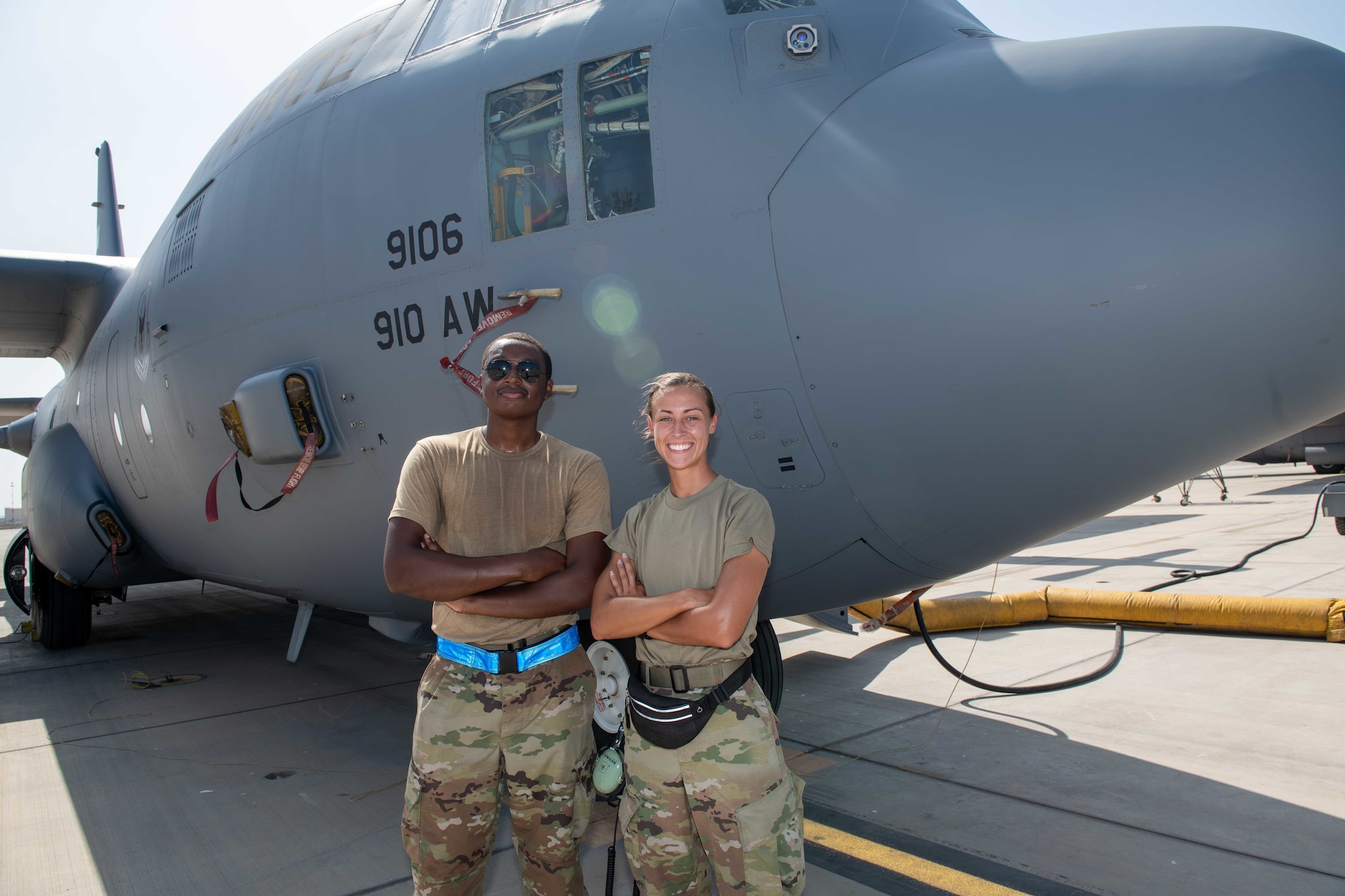 U.S. Air Force Reserve Senior Airman Justin Young (left), and Staff Sgt. Sydnie Schwenk, Airmen from Youngstown, Ohio, currently deployed to Camp Lemonnier, Djibouti, with the 75th Expeditionary Airlift Squadron "Rogue Squadron", stand in front of a C-130 Hercules assigned to the squadron, May 3, 2022.