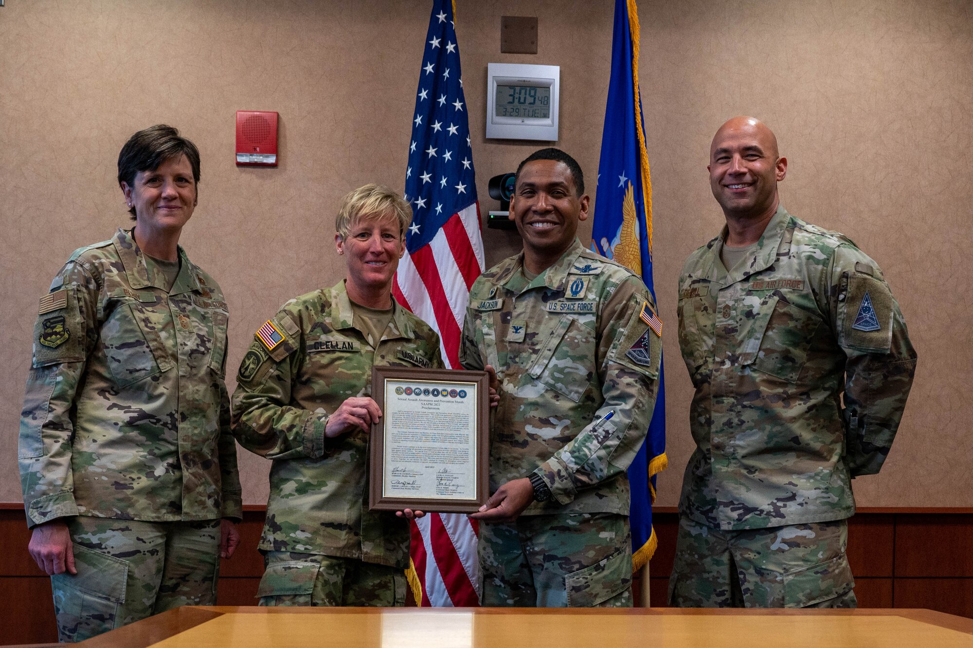 From left to right, U.S. Air Force Chief Master Sgt. Lisa Perry, 140th Wing command chief, U.S. Army Brig. Gen. Laura Clellan, Adjutant General, U.S. Space Force Col. Marcus Jackson, Buckley Garrison commander, and U.S. Air Force Chief Master Sgt. Robert Devall, Buckley Garrison command chief, gather around the Sexual Assault Awareness and Prevention Month proclamation at Buckley Space Force Base, Colo., March 29, 2022.