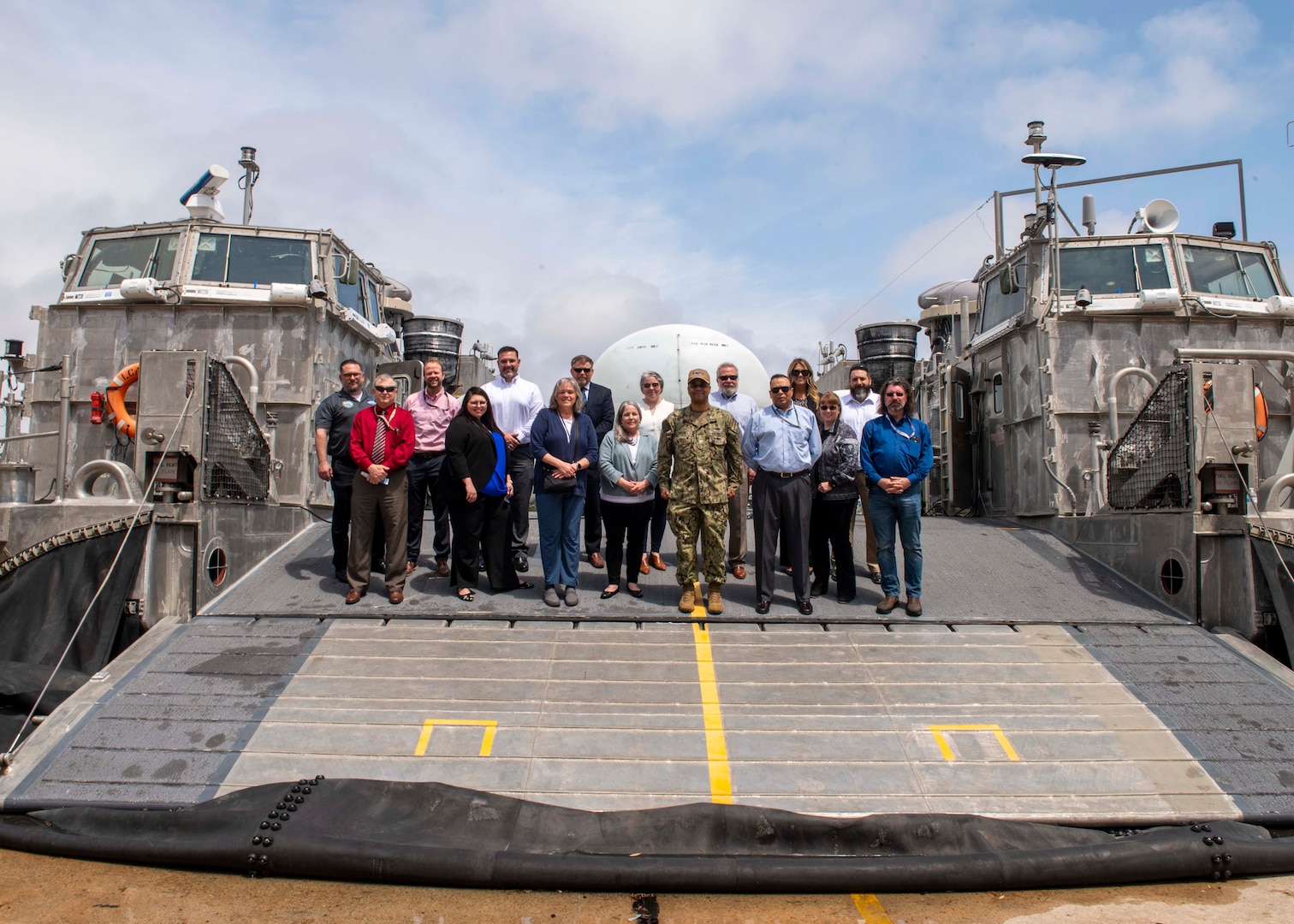 The Warfare Center Logistics Community of Practice (WFC Log CoP) stand aboard one of Naval Surface Warfare Center Panama City Division's landing craft air cushion vehicles during their in-person meeting and NSWC PCD tour, April 5-7. The goal of this event was to bring together the logistics leadership from each warfare center to share best practices, lessons learned, and to collaborate on ways to improve the logistics competency as a whole across the One Team enterprise. (U.S. Navy photo by Eddie Green)