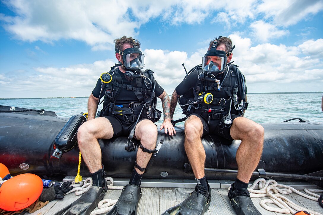 Sailor First Class Lucas Kozuch and Sailor First Class Brooks Robinson (left to right) from the Canadian Armed Forces prepare to enter the water for a reconnaissance dive during Exercise TRADEWINDS 2022 in Belize City, Belize on May 8, 2022.