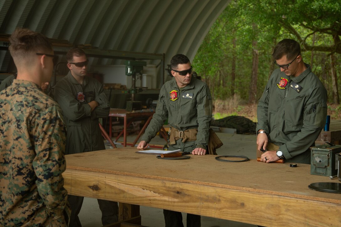 U.S. Marine Corps Staff Sgt. Destri Stemme, right, explosive ordnance disposal (EOD) technician, Headquarters and Headquarters Squadron, Marine Corps Air Station (MCAS) Beaufort, demonstrates how to lace detonation cord through dynamite at MCAS Beaufort, South Carolina, April 21, 2022. The EOD technicians were conducting standard training on MCAS Beaufort. (U.S. Marine Corps photo by Lance Cpl. Nathan Saucier)