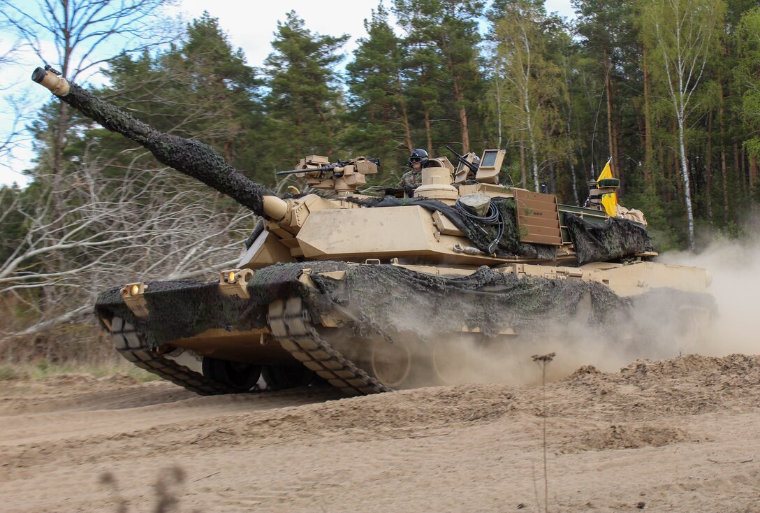 A tank travels down a dirt road.