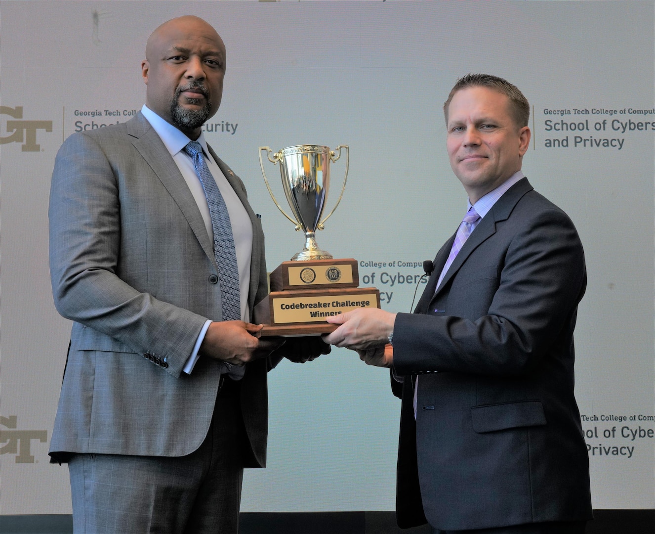 Dr. Charles Isbell, Georgia Tech's Dean of Computing, left, holds the Codebreaker Challenge trophy alongside COL Richard Malagna, NSA-Georgia Director.
