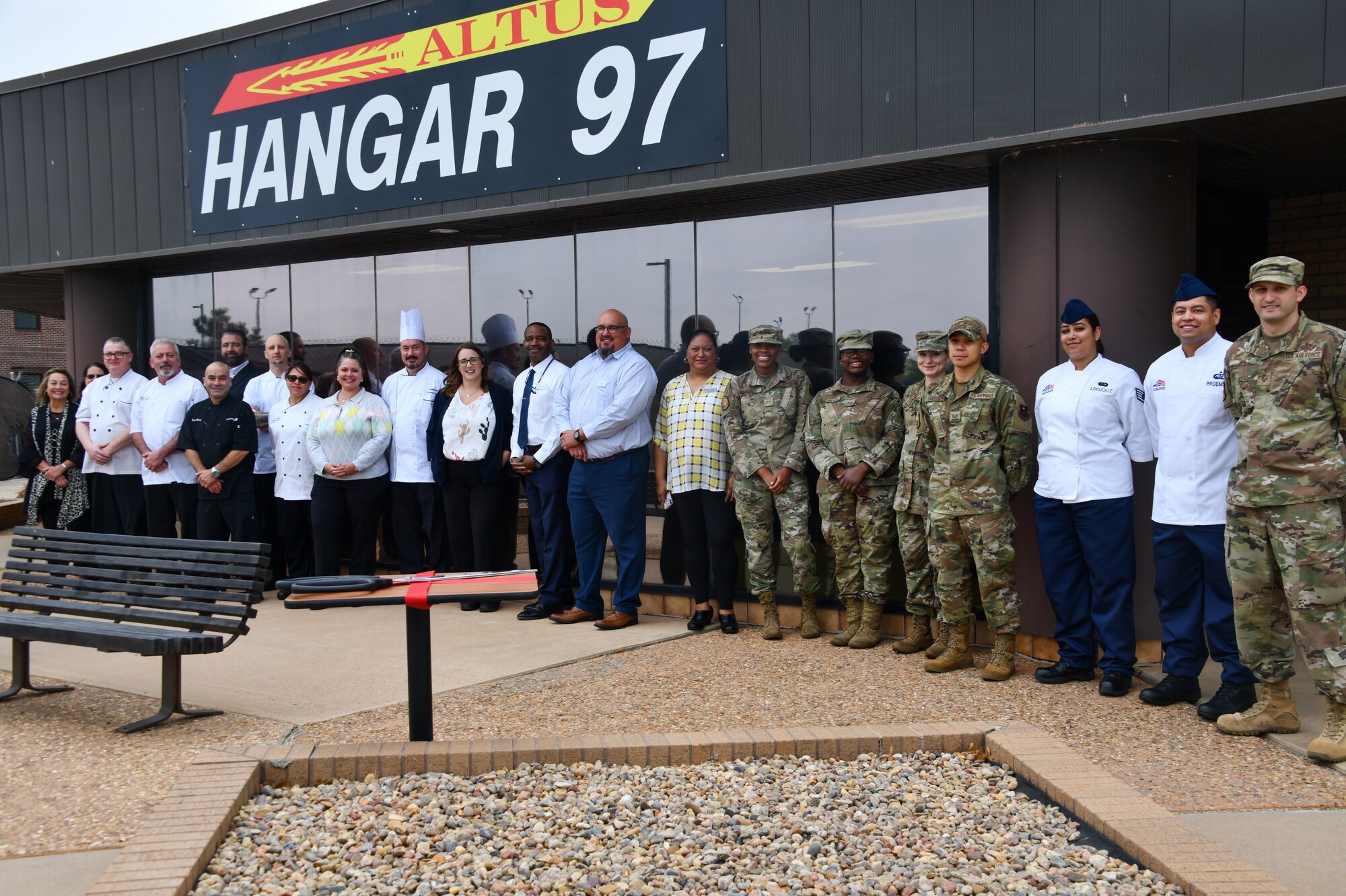 Members of the 97th Force Support Squadron sustainment services flight pose for a photo in front of Hangar 97 at Altus Air Force Base, Oklahoma, April 28, 2022. The facility reopened after 12 months of renovation. (U.S. Air Force photo by Airman 1st Class Miyah Gray)