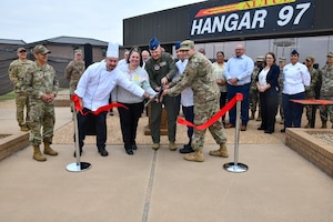 U.S. Air Force Col. Blaine Baker (center), 97th Air Mobility Wing commander, and leaders from the 97th Force Support Squadron sustainment services flight, cut a ribbon at the re-opening of Hangar 97 at Altus Air Force Base, Oklahoma, April 28, 2022. The upgraded facility will feature a variety of new menu items. (U.S. Air Force photo by Airman 1st Class Miyah Gray)