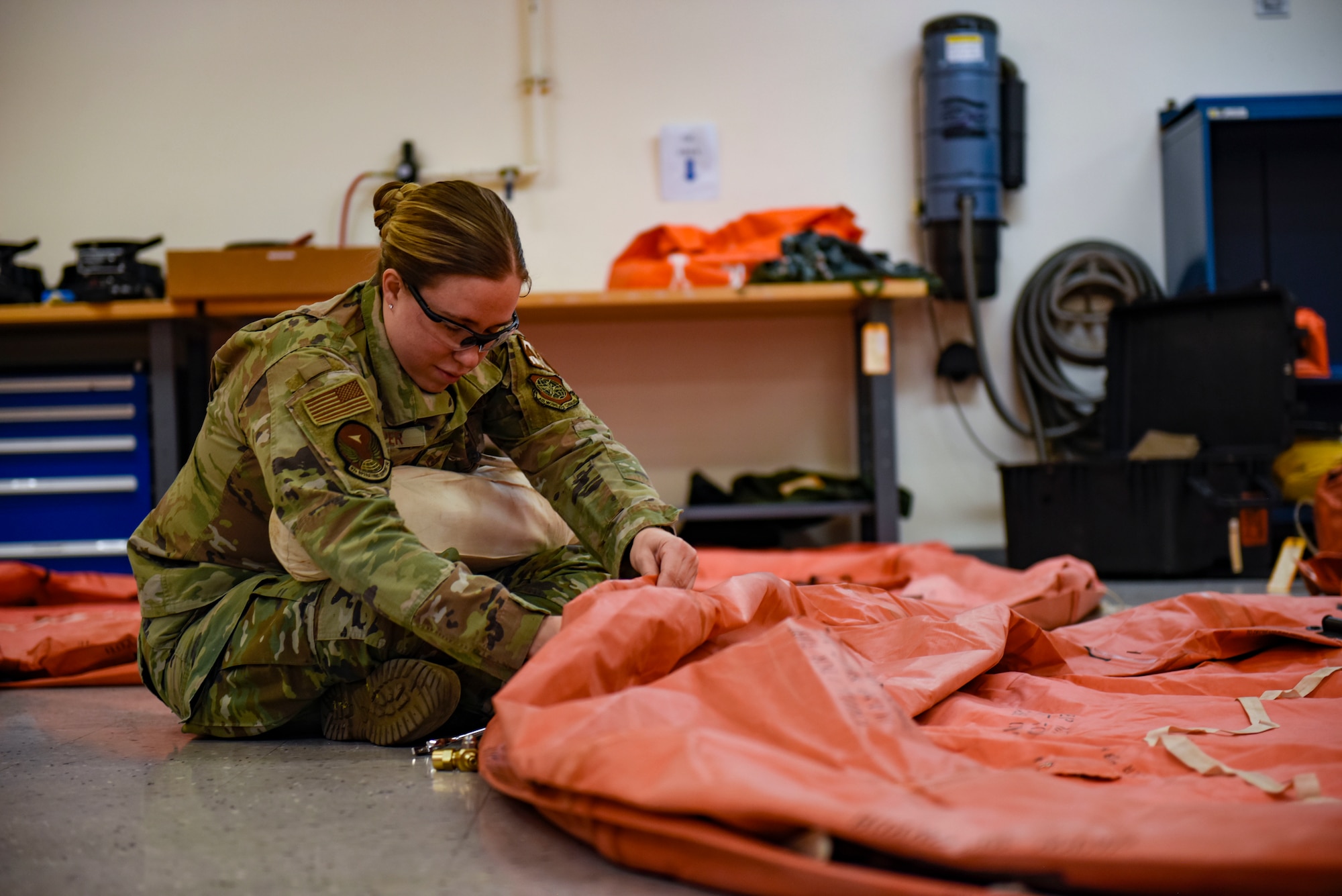 U.S. Air Force Staff Sgt. Nicole Harper, 92nd Operation Support Squadron Aircrew Flight Equipment technician, works on inflating a 20-man raft on Fairchild Air Force Base, Washington, May 3, 2022. AFE ensures mission readiness and safety by thoroughly examining and repairing essential gear. (U.S. Air Force photo by Airmen 1st Class Haiden Morris)