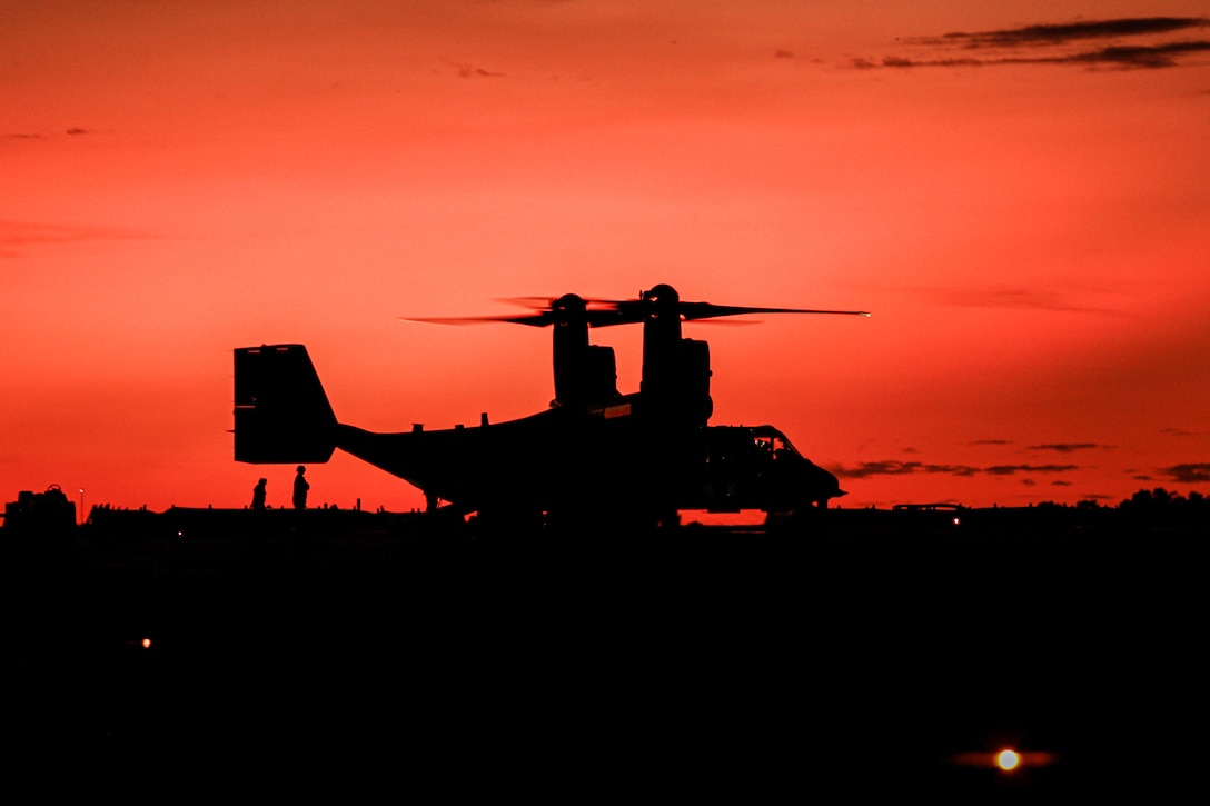 An aircraft is seen against a reddish sky.