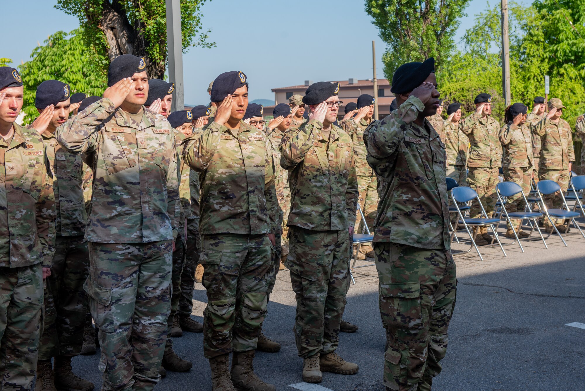 Members of the 51st Security Forces Squadron stand and salute during the police week opening ceremony.