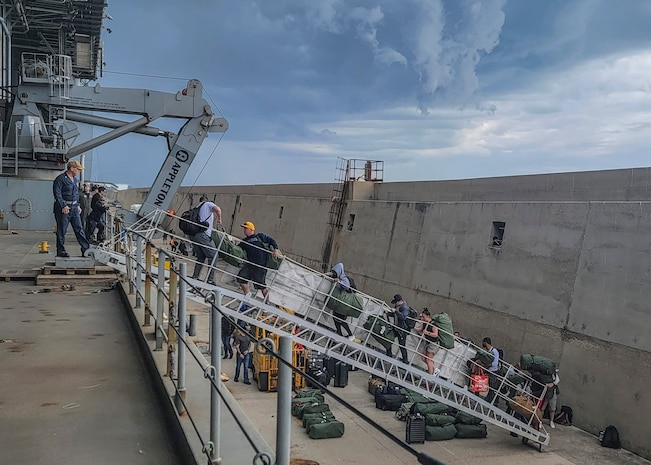 Capt. Michael Concannon, commanding officer of the GOLD Military Crew aboard the Expeditionary Sea Base USS Hershel "Woody" Williams (ESB 4), stands atop the brow welcoming Sailors from the BLUE military crew while they move aboard to conduct an exchange of command, May 8, 2022. Hershel "Woody" Williams is on a scheduled deployment in the U.S. Sixth Fleet area of operations in support of U.S. national interests and security in Europe and Africa.