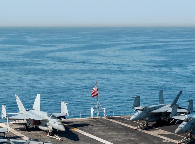 220510-N-ZE328-1019 NAPLES, Italy (May 10, 2022) Sailors raise the national ensign on the flight deck of the Nimitz-class aircraft carrier USS Harry S. Truman (CVN 75) as the ship pulls into Naples, Italy for a scheduled port visit, May 10, 2022. The Harry S. Truman Carrier Strike Group is on a scheduled deployment in the U.S. Sixth Fleet area of operations in support of U.S., Allied and partner interests in Europe and Africa. (U.S. Navy photo by Mass Communication Specialist 2nd Kelsey Trinh)