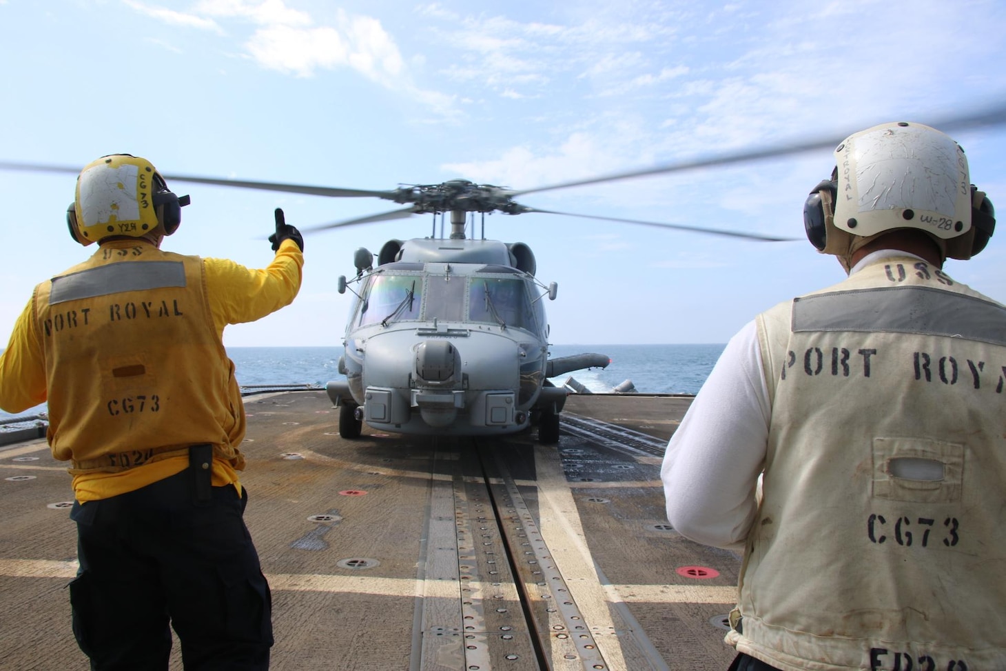 220510-N-NO824-1011 TAIWAN STRAIT (May 10, 2022) Boatswain’s Mate 2nd Class Olivo, from Lot, Oklahoma, and Boatswain’s Mate 1st Class Michael Bergado from Ewa Beach, Hawaii, signals takeoff to the pilot of an MH-60R Sea Hawk helicopter, attached to the “Easyriders” of Helicopter Maritime Strike Squadron (HSM) 37, during flight quarters aboard the Ticonderoga-class guided-missile cruiser USS Port Royal (CG 73) as the ship conducts a routine Taiwan Strait transit May 10. Port Royal is forward-deployed to the 7th Fleet area of operations in support of a free and open Indo-Pacific. (U.S. Navy photo by Ensign Jessika Stanback)
