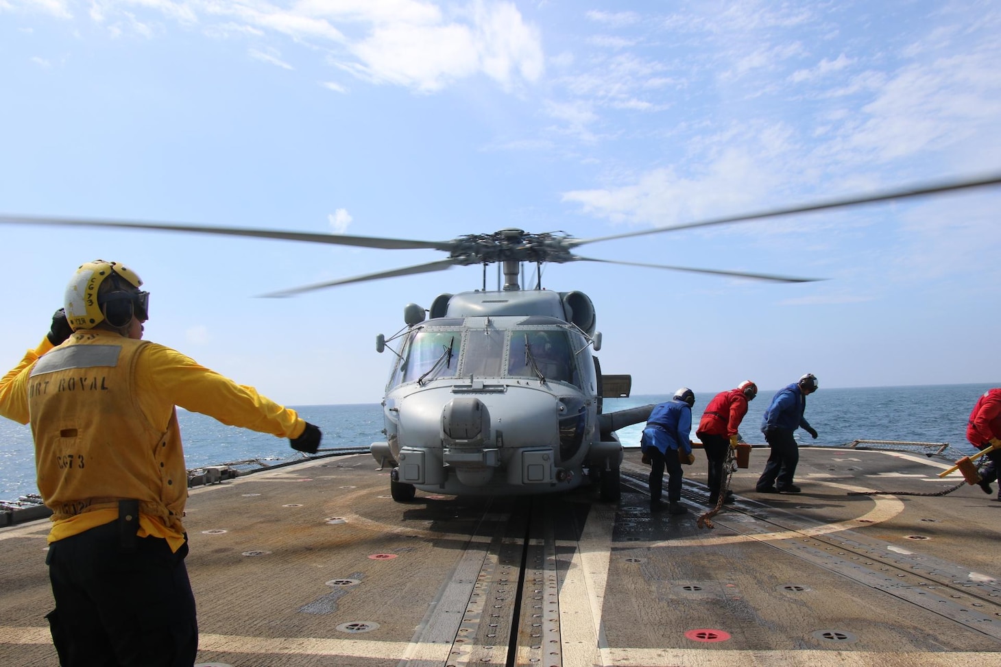 220510-N-NO824-1022 TAIWAN STRAIT (May 10, 2022) Sailors retrieve chock and chains from an MH-60R Sea Hawk helicopter, attached to the “Easyriders” of Helicopter Maritime Strike Squadron (HSM) 37, prior to takeoff on the flight deck of the Ticonderoga-class guided-missile cruiser USS Port Royal (CG 73) as the ship conducts a routine Taiwan Strait transit May 10. Port Royal is forward-deployed to the 7th Fleet area of operations in support of a free and open Indo-Pacific. (U.S. Navy photo by Ensign Jessika Stanback)