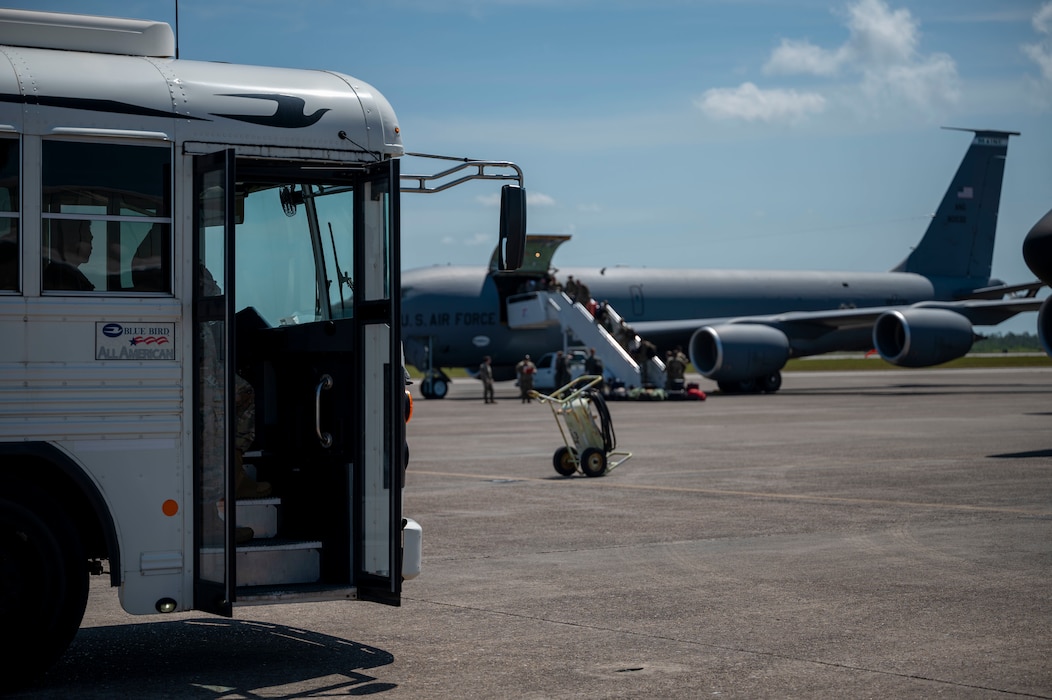A bus and a cargo plane wait on the flight line