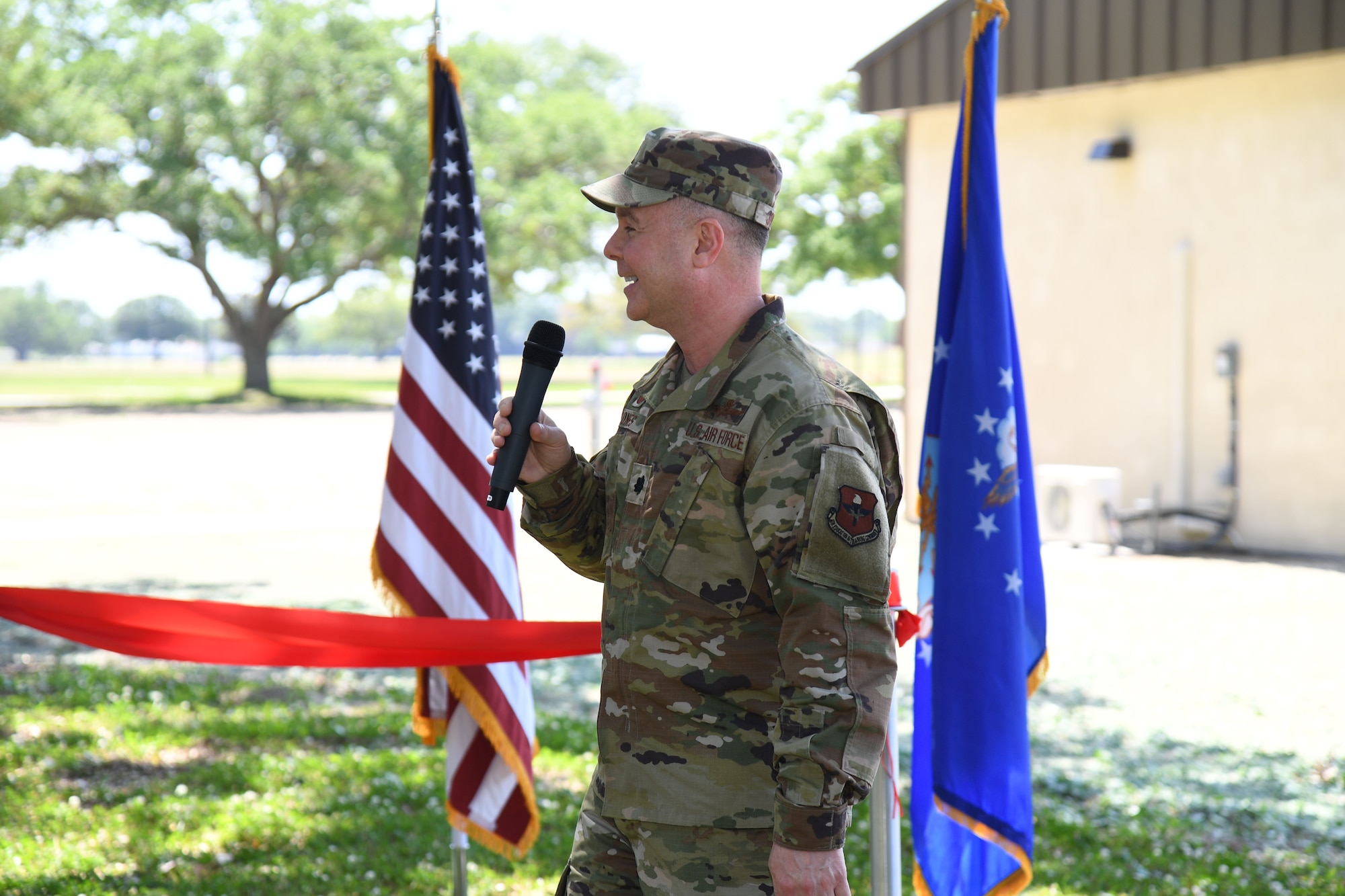 U.S. Air Force Lt. Col. Tobiah Jones, 338th Training Squadron commander, delivers remarks during the Air Expeditionary Force Ribbon Cutting Ceremony behind Jones Hall at Keesler Air Force Base, Mississippi, May 4, 2022. The AEF Training Area supports more than 700 students annually for the Radio Frequency Operations Apprentice Course. (U.S. Air Force photo by Kemberly Groue)